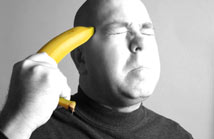 Desperate man holding banana to his head